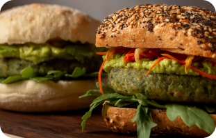 Vegetarian burger patty in a soft bun, served with fresh vegetables.